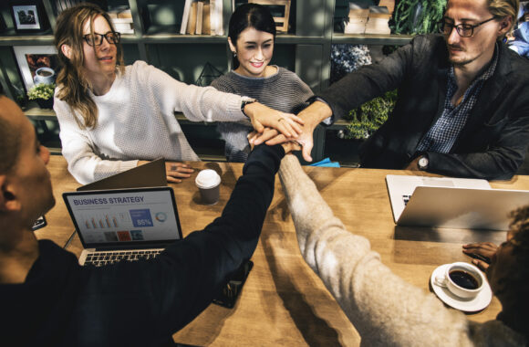 Diverse people stacking hands together